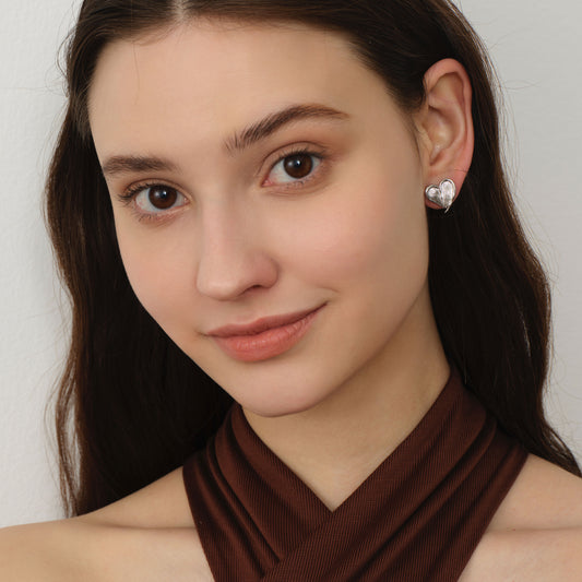 Front profile of a model wearing TIKOO textured heart studs, a minimalist yet bold jewelry statement.