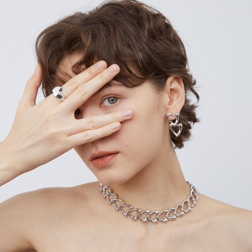 Detailed side view of the TIKOO thick rhodium-plated heart chain necklace, highlighting its lustrous metallic finish.