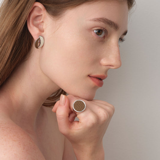 Fashion model wearing the TIKOO brown leather signet ring and matching earrings, showcasing a coordinated quiet luxury look.