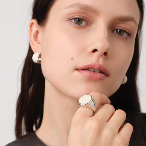 Close-up of a model wearing the TIKOO chunky round leather signet ring, highlighting its sculptural design and premium finish.
