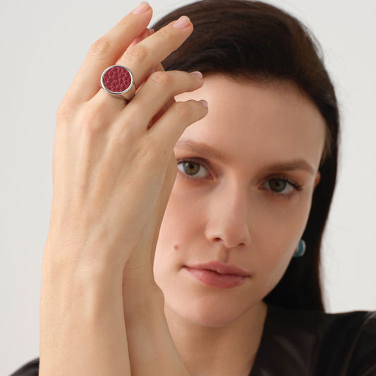 Close-up of a model wearing the TIKOO wine red leather signet ring, highlighting its sculptural design and premium finish.