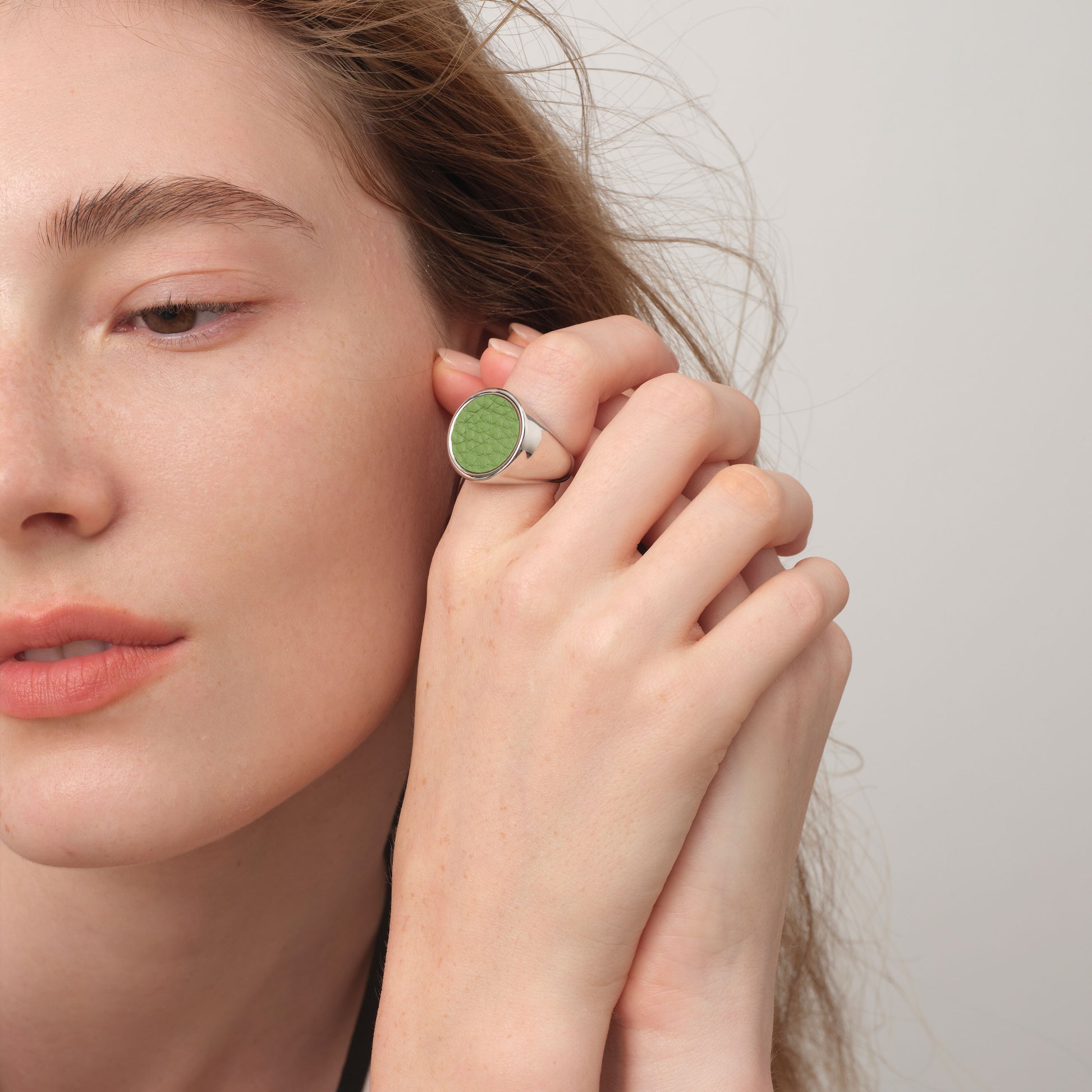 Fashion model wearing the TIKOO sage green leather inlay ring, showcasing its chunky minimalist design and premium texture.
