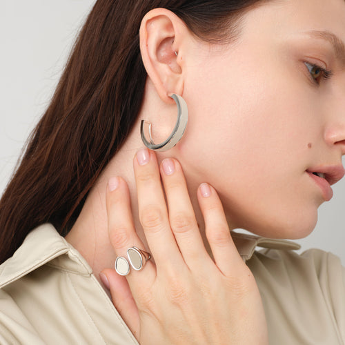 Fashion model wearing TIKOO large white leather hoop earrings, showcasing the clean girl aesthetic and minimalist jewelry trend.