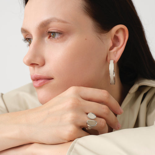 Fashion model wearing TIKOO large white leather hoop earrings, showcasing the clean girl aesthetic and minimalist jewelry trend.