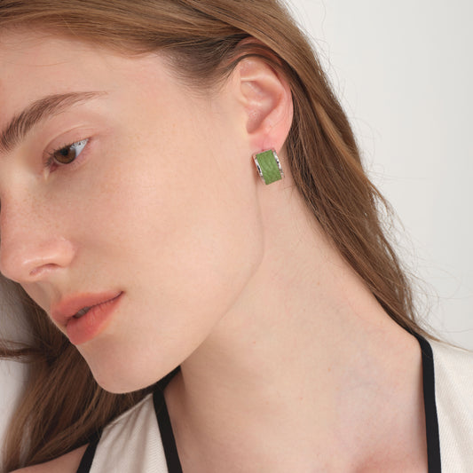 Side view of model wearing TIKOO premium leather inlay earrings, highlighting the textured leather and brilliant silver-tone finish.