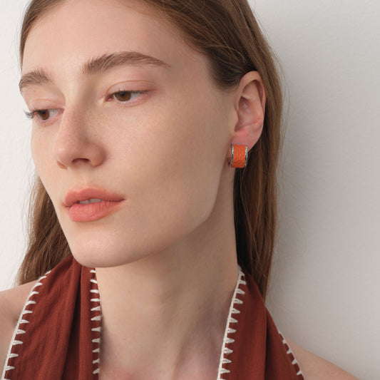 Close-up side view of model wearing TIKOO premium leather inlay earrings, highlighting the texture and silver shine.