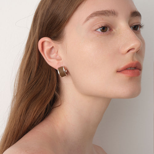 Fashion model wearing TIKOO brown leather inlay earrings, showcasing a minimalist and elegant jewelry look.