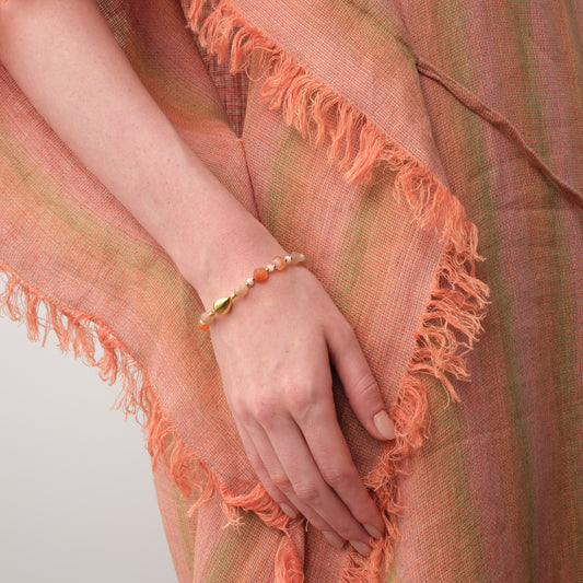 A model wearing the TIKOO multi-color moonstone bracelet, showcasing the warm tones and gold magnetic closure against a boho-style outfit.