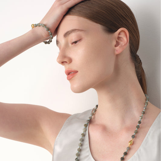 A model wearing the TIKOO labradorite bracelet, showcasing the mystical blue flashes of the natural stone.