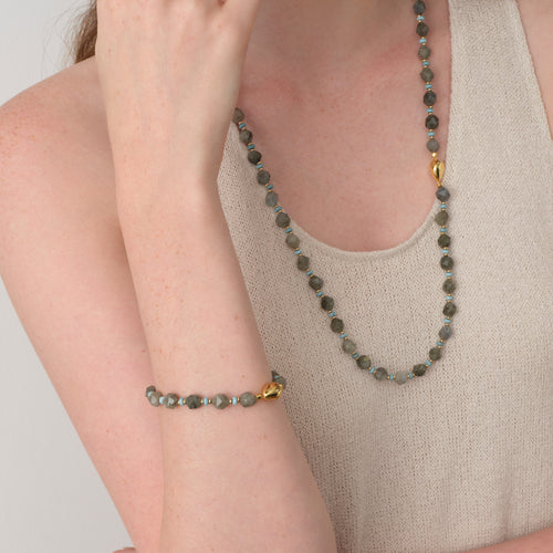 Close-up of a model styling the TIKOO labradorite bracelet and matching long necklace for a sophisticated layered look.