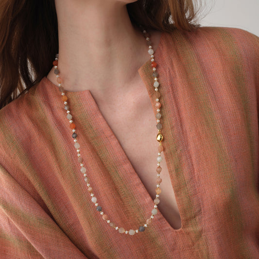 Close-up of a model wearing the TIKOO moonstone long necklace, highlighting the delicate gemstone textures and 18K gold accents.