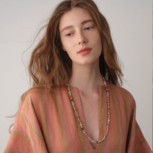 A model showcasing the elegant drape of the TIKOO moonstone long necklace, perfect for sustainable luxury fashion styling.