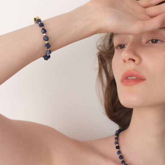 Lifestyle shot of the TIKOO blue stone bracelet with 18K gold accents on model's arm.