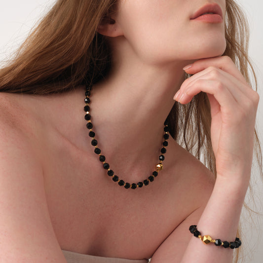 Style inspiration featuring the TIKOO black onyx necklace and matching bracelet on a model, highlighting the thick gold plating and gemstone texture.
