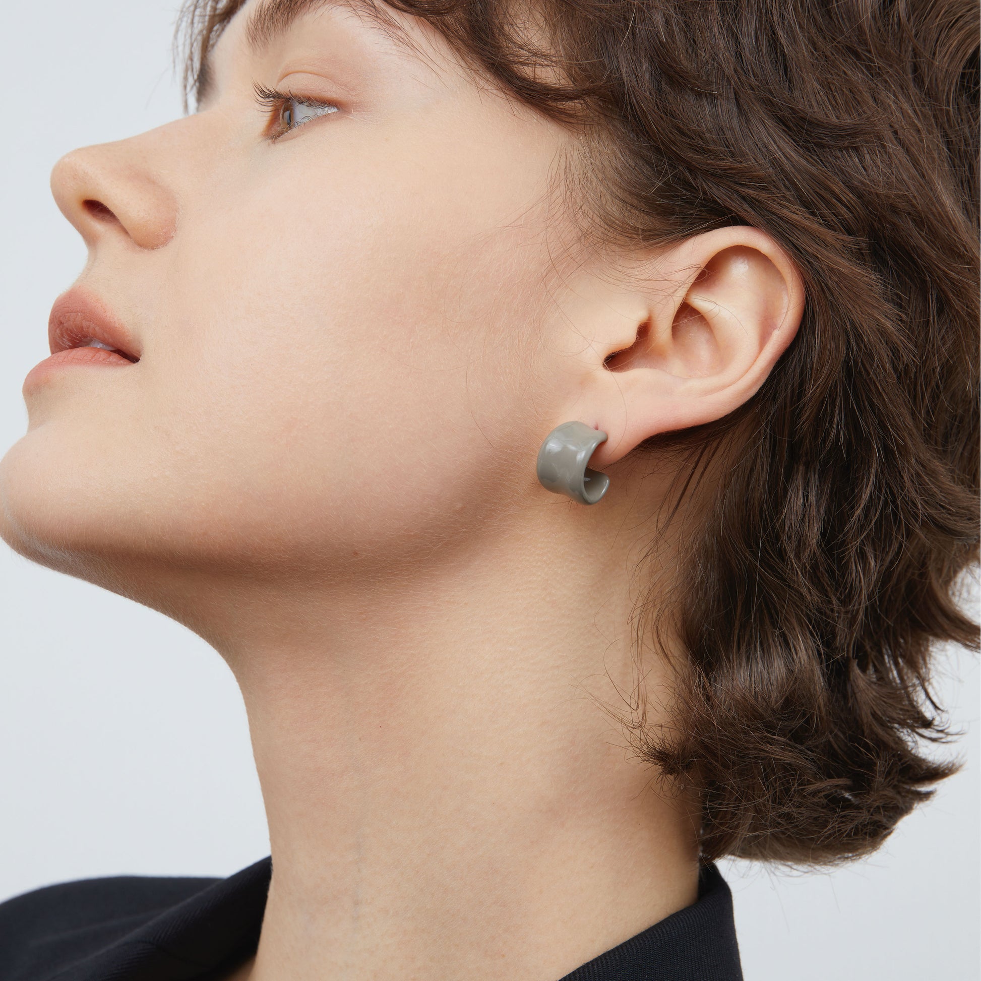 Close-up of TIKOO grey enamel C-shape earrings highlighting the glossy architectural design.