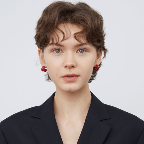 Front view of a model wearing TIKOO minimalist deep red enamel hoop earrings, showcasing the color and size.