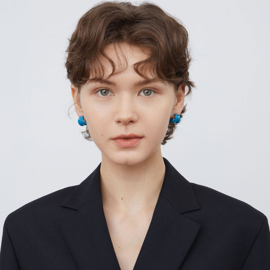 Model wearing TIKOO blue enamel hoops with a black blazer for a professional look.