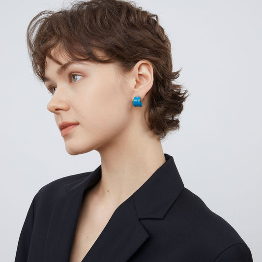Side view of bold blue sculptural C-shaped earrings by TIKOO.
