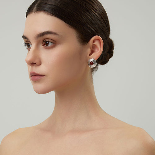 Close-up shot showing the intricate geometric ridges of the platinum-plated red jasper earrings.