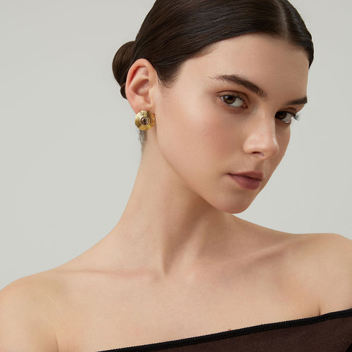 Side view of a model wearing TIKOO bold geometric gold studs with earthy smoky quartz gemstone.