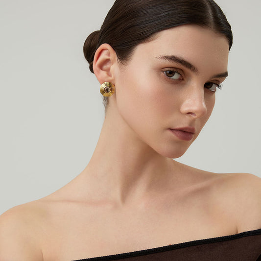 Side view of a model wearing TIKOO bold geometric gold studs with earthy smoky quartz gemstone.