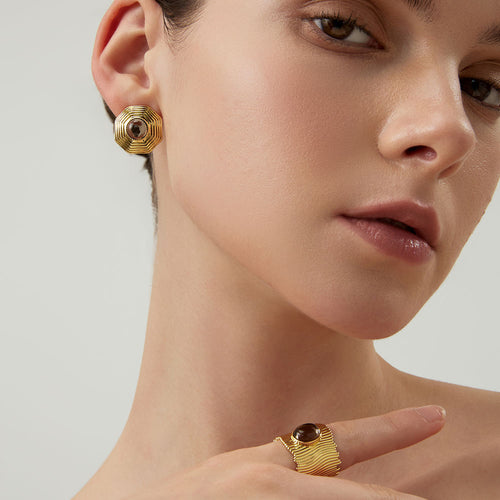 Side view of a model wearing TIKOO bold geometric gold studs with earthy smoky quartz gemstone.