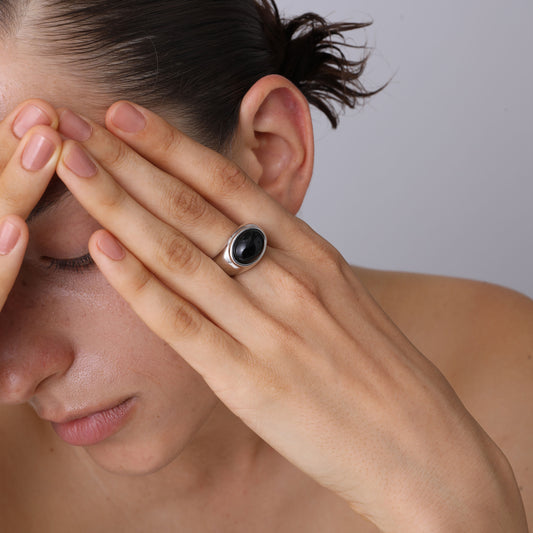 Model wearing the TIKOO platinum-plated silver ring, highlighting the smooth polished finish and gemstone detail.