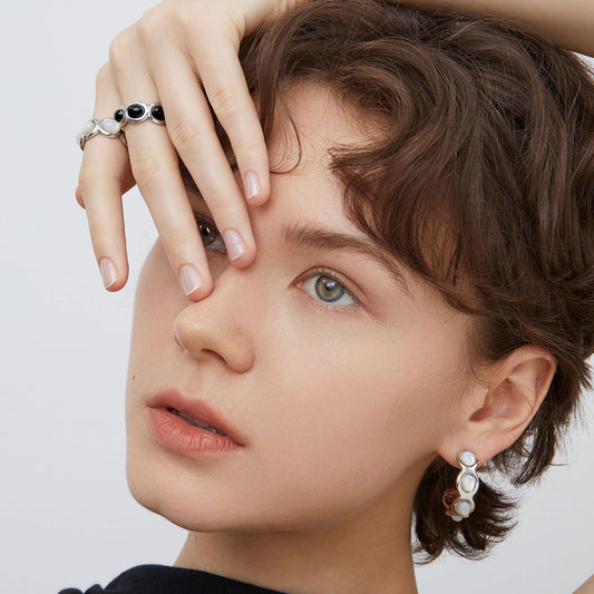 Front view of a model wearing TIKOO platinum plated mother of pearl hoops, highlighting the elegant iridescent glow.