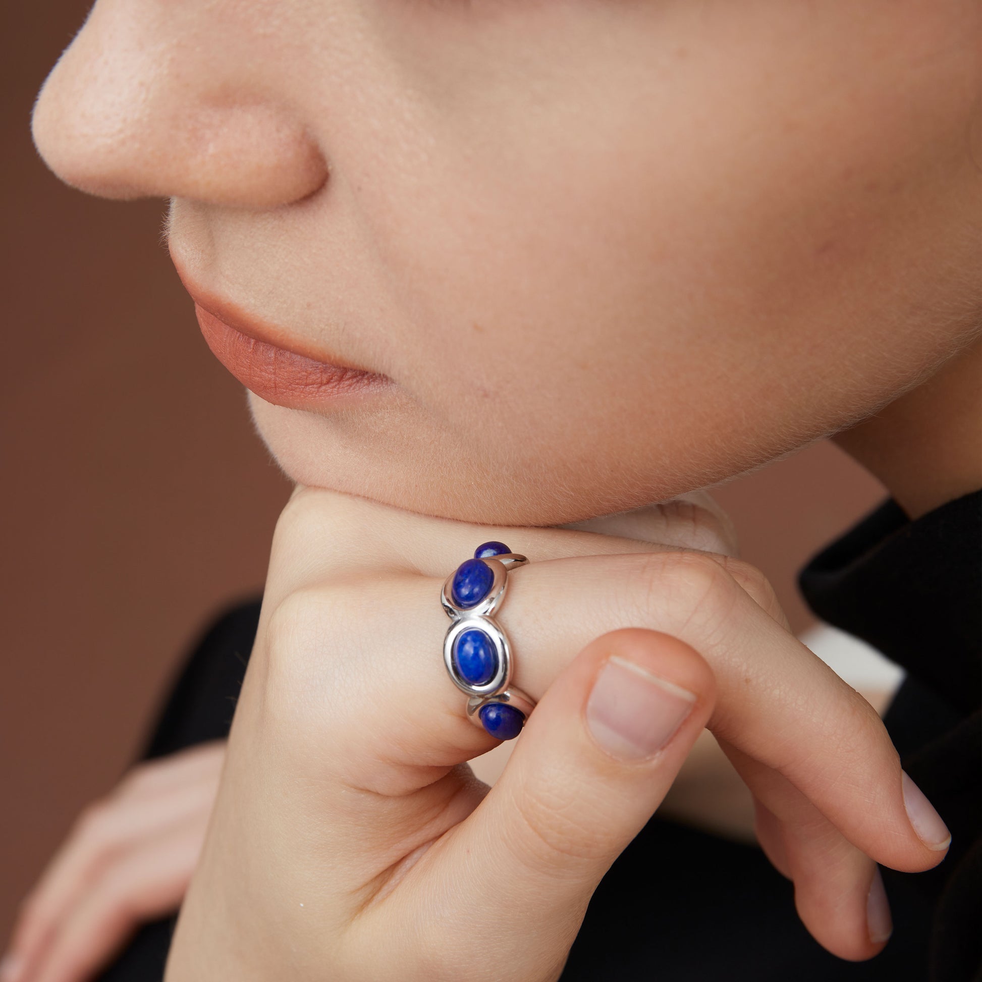 Close-up view of a model wearing the TIKOO blue lapis wave ring, highlighting the vibrant stone color.
