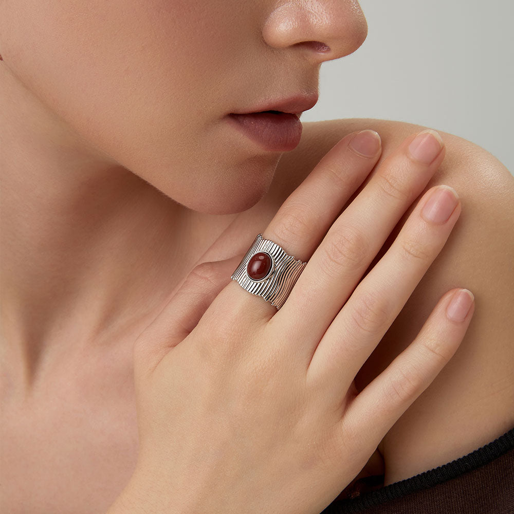 Close-up of a model wearing the TIKOO bold red stone wide band ring in platinum finish.