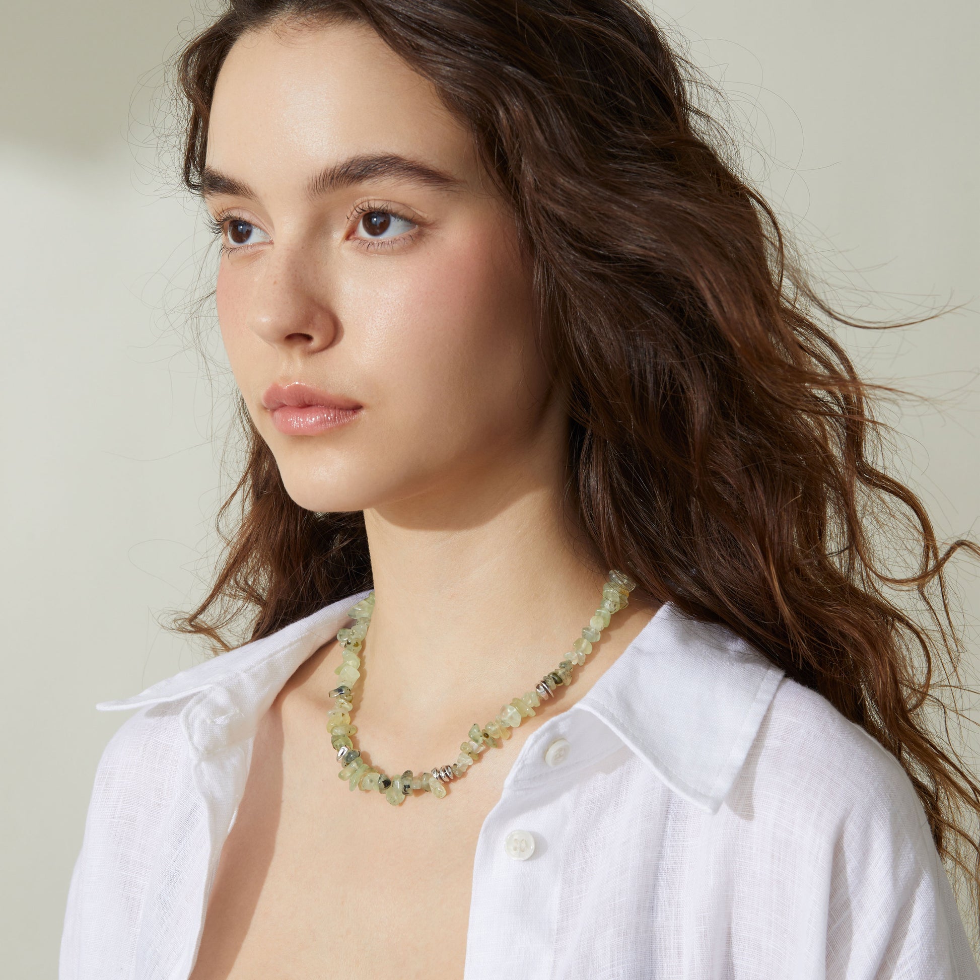 Professional model showcasing the TIKOO prehnite beaded necklace, styled with a minimalist white linen shirt for a modern everyday look.