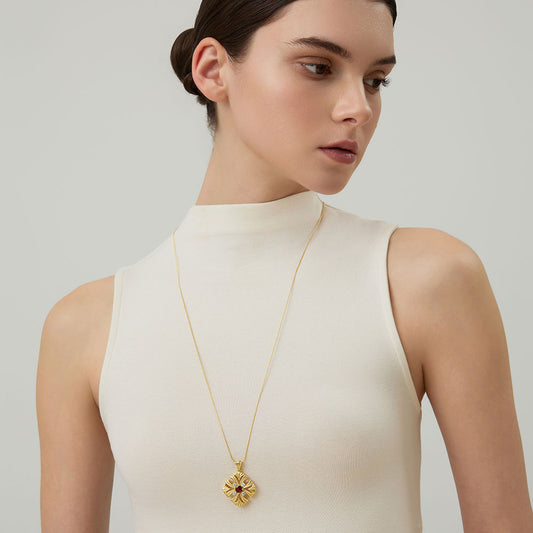 Close-up of the TIKOO garnet and Moissanite cross pendant, highlighting the intricate gold craftsmanship.