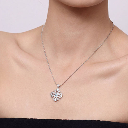 Close-up of a model wearing TIKOO Art Deco necklace featuring sparkling blue and white gemstones.