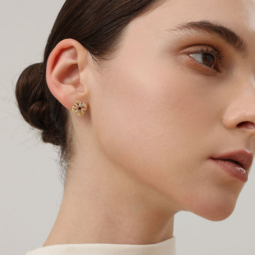 Side profile of a model showcasing the intricate vintage cross flower design of the TIKOO garnet earrings.