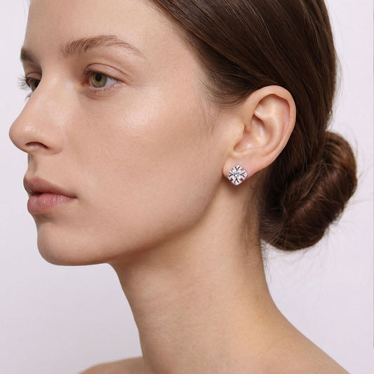 Close-up of a model wearing TIKOO Art Deco floral earrings with blue gemstone and sparkling accents.