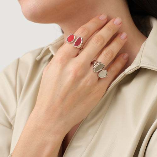 Model stacking TIKOO red and khaki leather rings, demonstrating the adjustable open-wrap design and mixed-media texture.