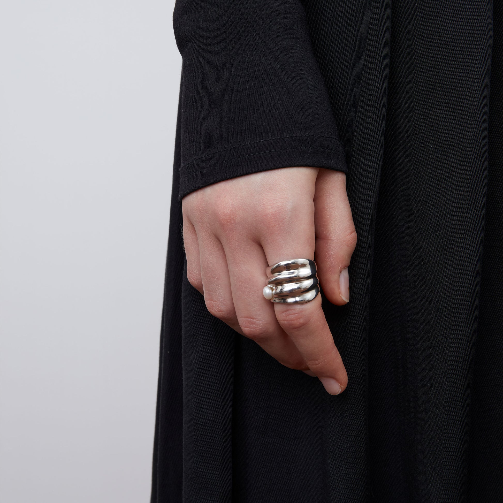 Close-up of a model wearing TIKOO bold irregular silver-tone ring with a small white pearl.