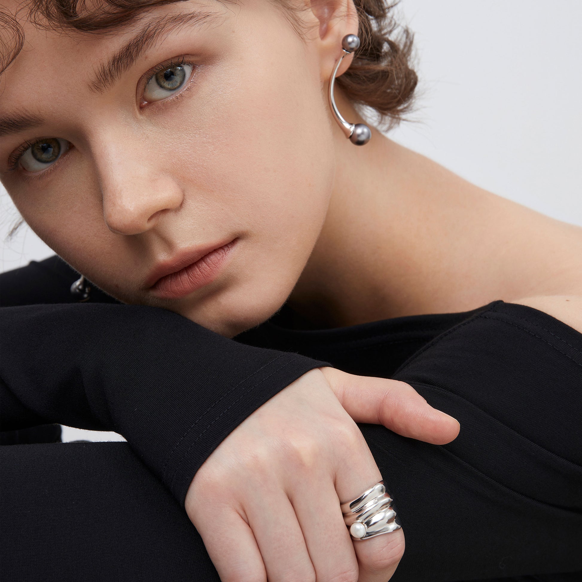 Fashion model showcasing a TIKOO fluid design pearl ring, emphasizing its modern and sculptural aesthetic.