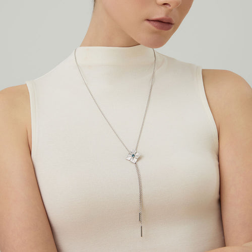 Model wearing TIKOO original London blue topaz long necklace over a high-neck white top, showcasing the elegant drop.
