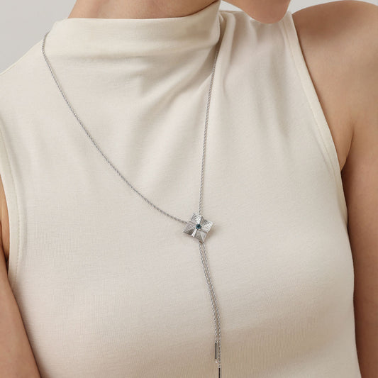 Side profile of model wearing the TIKOO architectural blue topaz pendant with long adjustable chain.