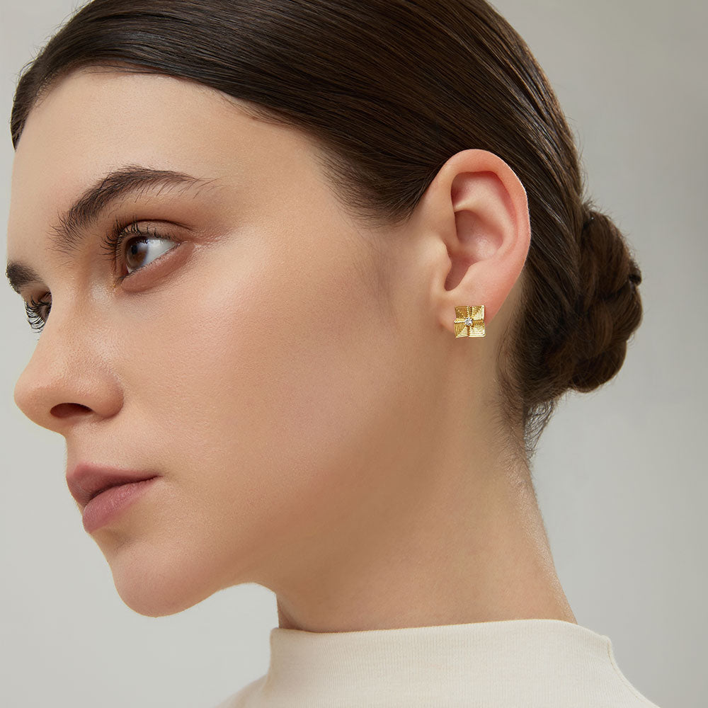 Side profile of model showing the sculptural texture of TIKOO gold geometric earrings.